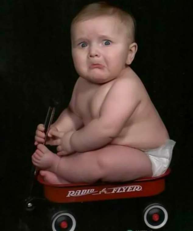 Грустный Маленький мальчик сидит на тележке с надписью RADIO FLYER