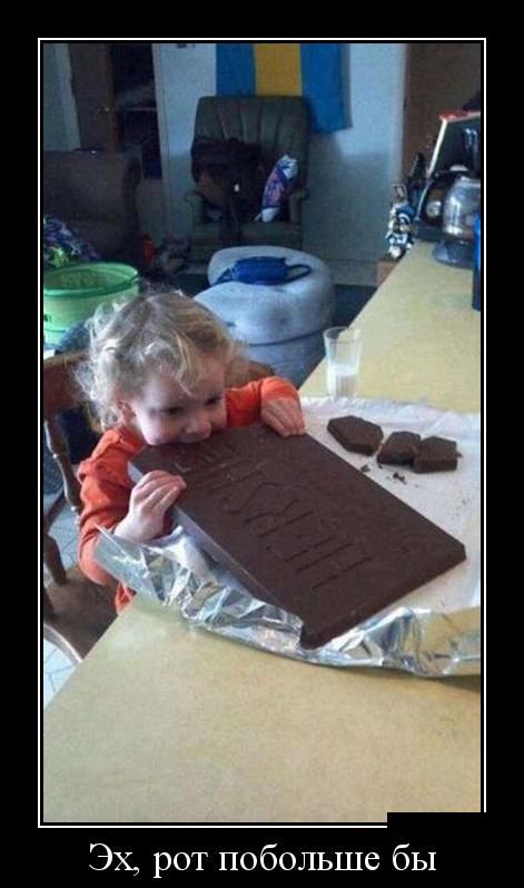 маленькая девочка кусает огромную шоколадку.