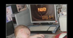 Маленький мальчик спит за компьютером