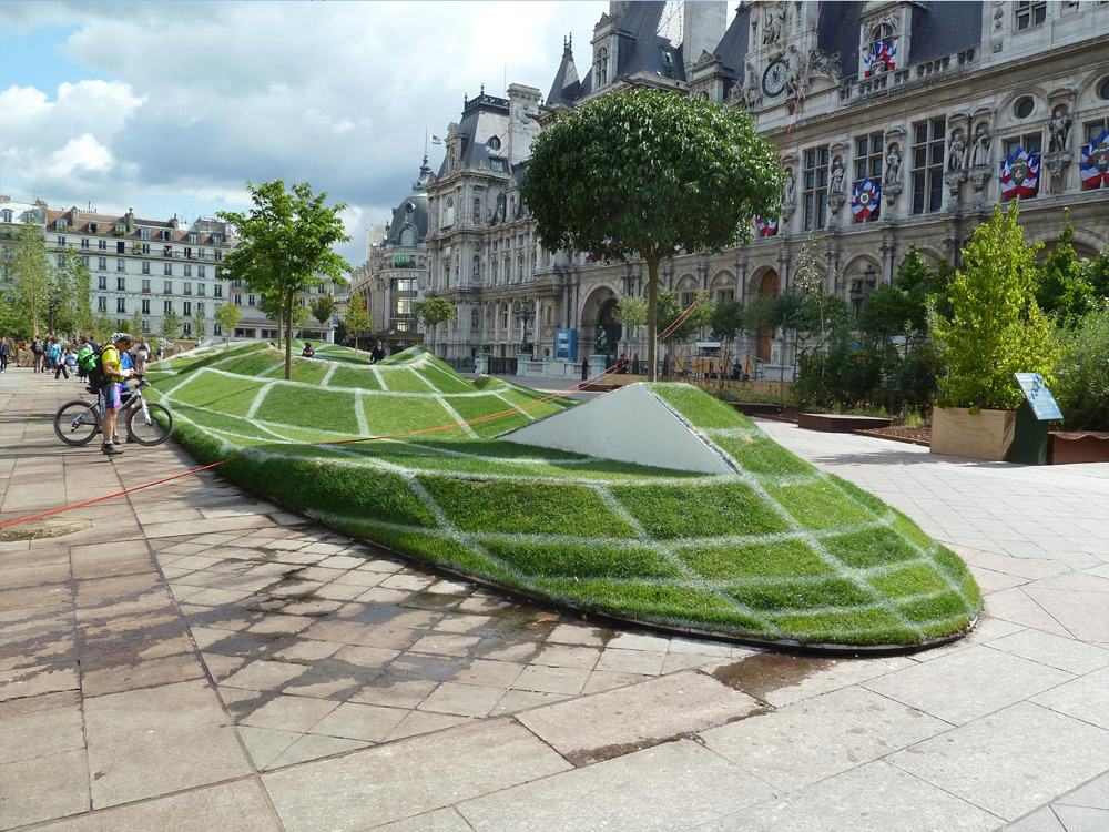 Зеленый газон на площади в париже.